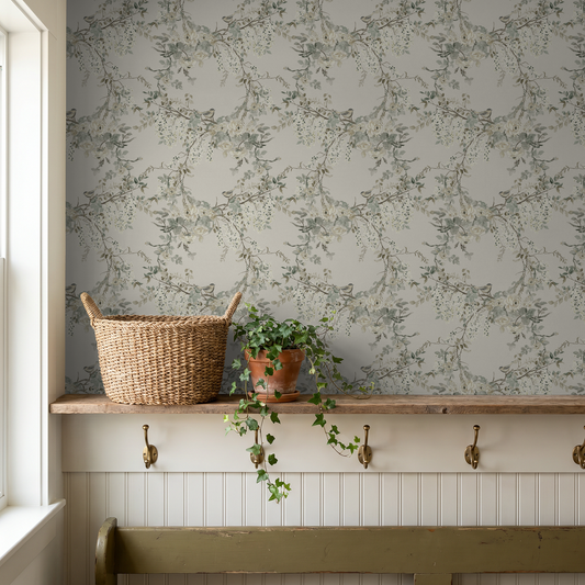Floral wallpaper with delicate branches and blossoms in soft greens and creams in a cozy room setting.