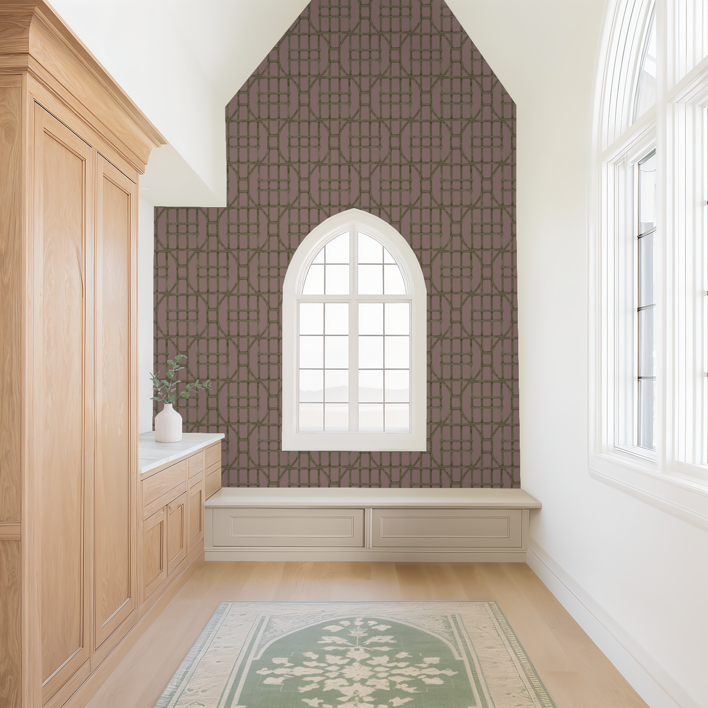 Geometric trellis wallpaper in earthy green on blush background in bright room with wooden furniture.