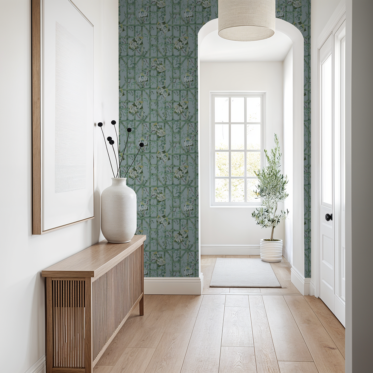 Green trellis wallpaper with hydrangea pattern in a bright hallway with wooden furniture.
