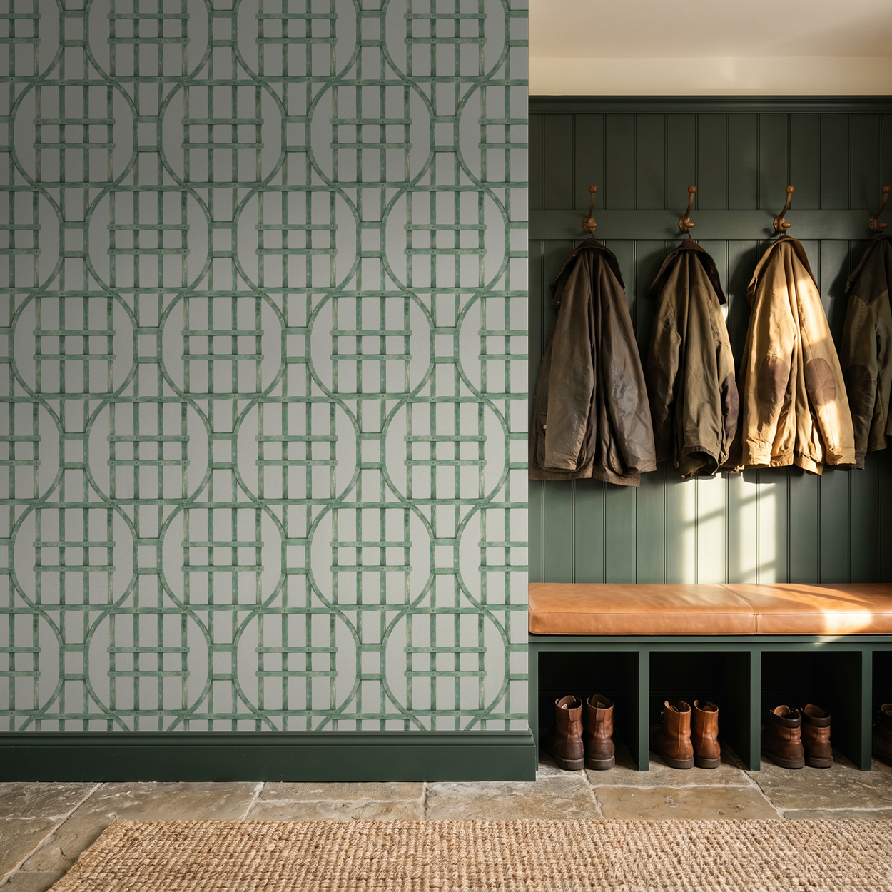Green trellis wallpaper on bisque background in a rustic entryway with coats and boots.