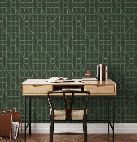 Green trellis wallpaper in home office with wooden desk and chair.