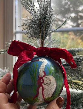 Decorative ornament with a bird design held in front of a window