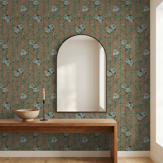 Hydrangea wallpaper with green trellis on burnt orange in modern room with mirror.