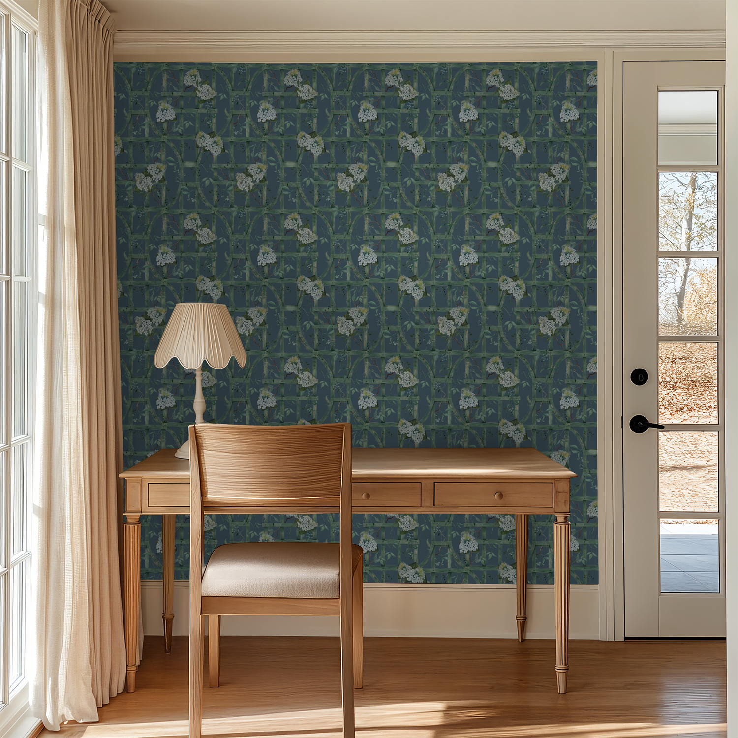 Deep blue wallpaper with green trellis and white hydrangeas in a sunlit room with wooden desk.