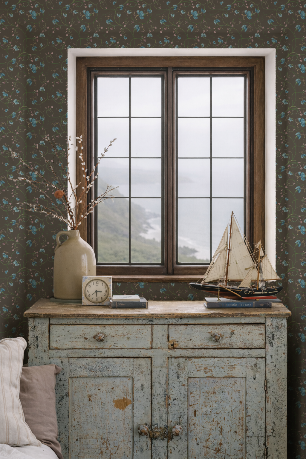 Vintage-style room with a wooden sideboard, vase with branches, clock, and model sailboat.