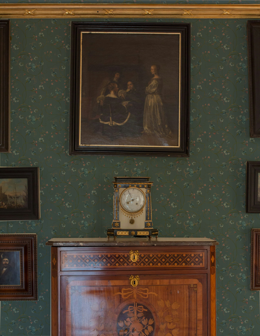 Decorative interior with a clock on a wooden cabinet against a patterned wall.