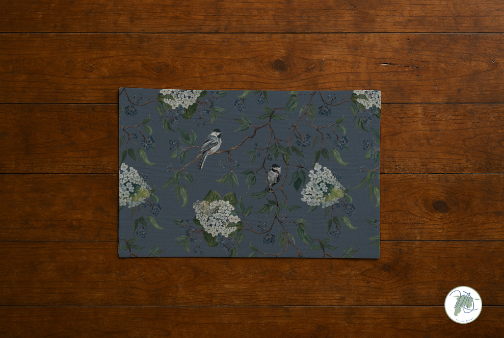 Decorative placemat with bird and flower design on a wooden surface