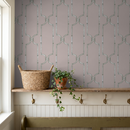 Trellis motif wallpaper in blush with basket and plant in rustic room.