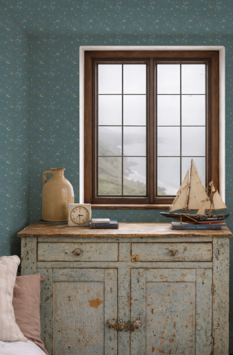 Vintage-style window with decorative items on a wooden cabinet against a teal wall.