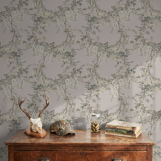 Vintage floral and bird wallpaper with soft pastel blooms and branches in a rustic room setting.