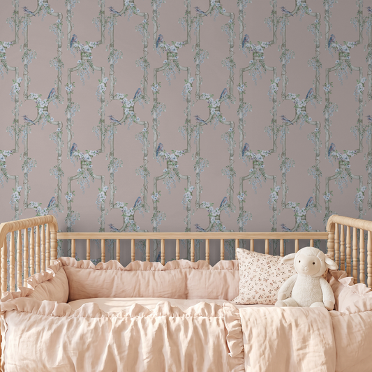 Vintage rose bird and floral trellis wallpaper in a nursery with a wooden crib.