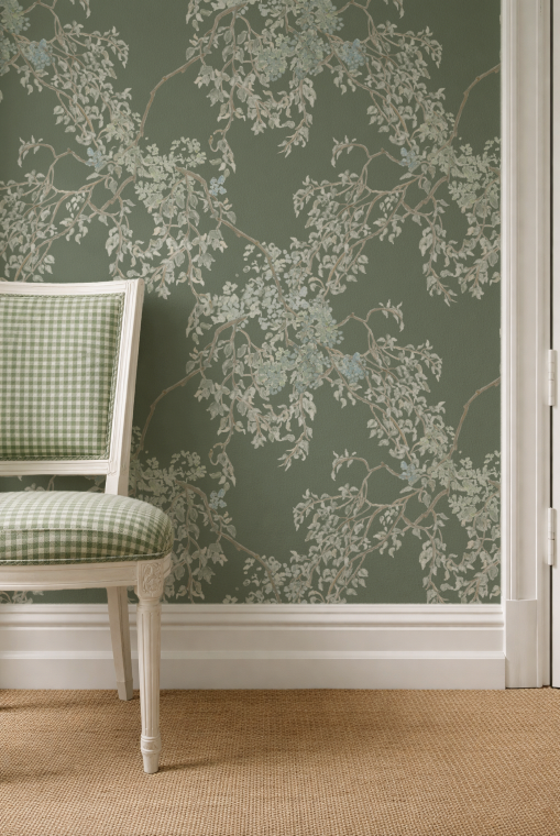 Wallpaper with floral pattern on a green wall with a chair in front.