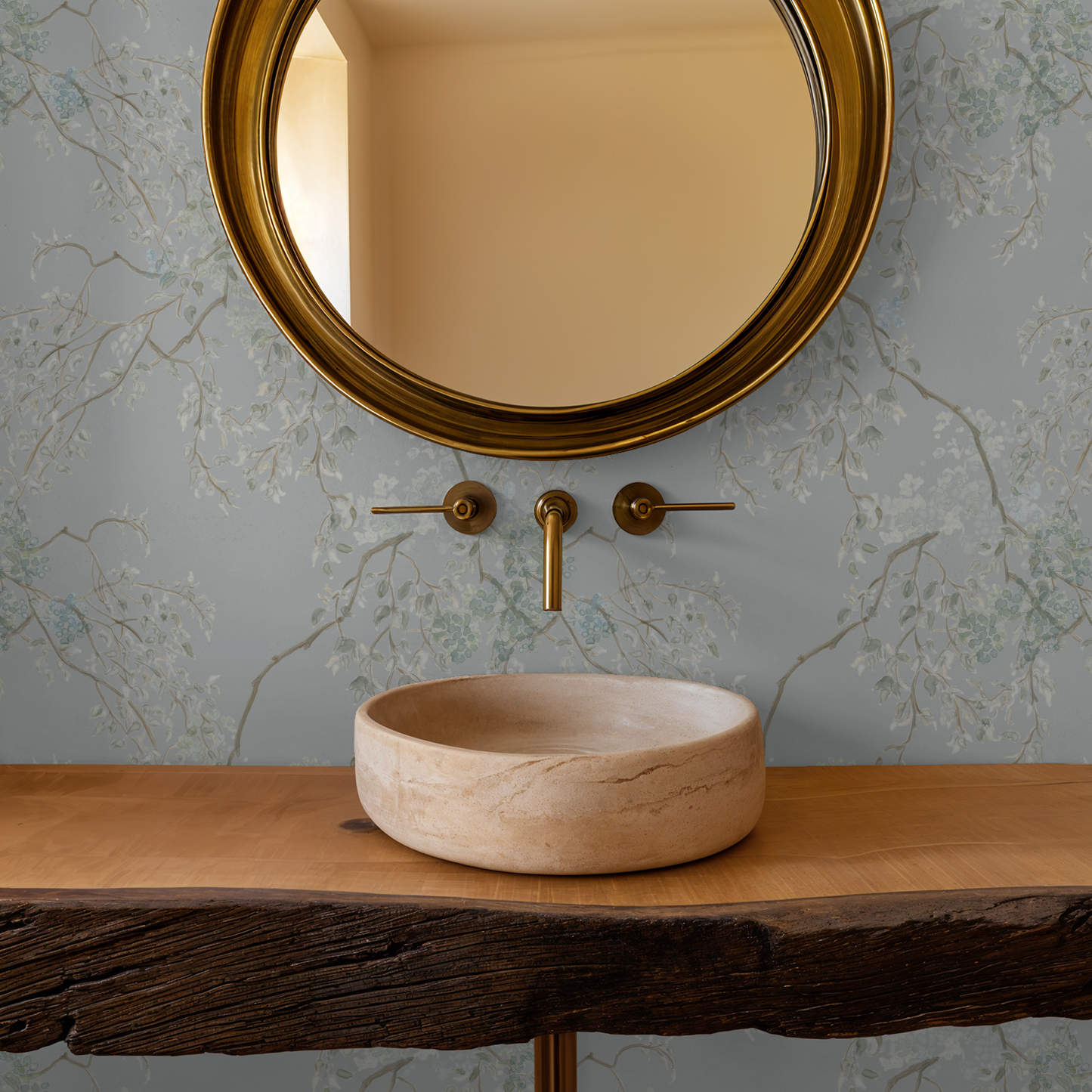 Bathroom setup with a round mirror, faucet, and stone sink on a wooden vanity.