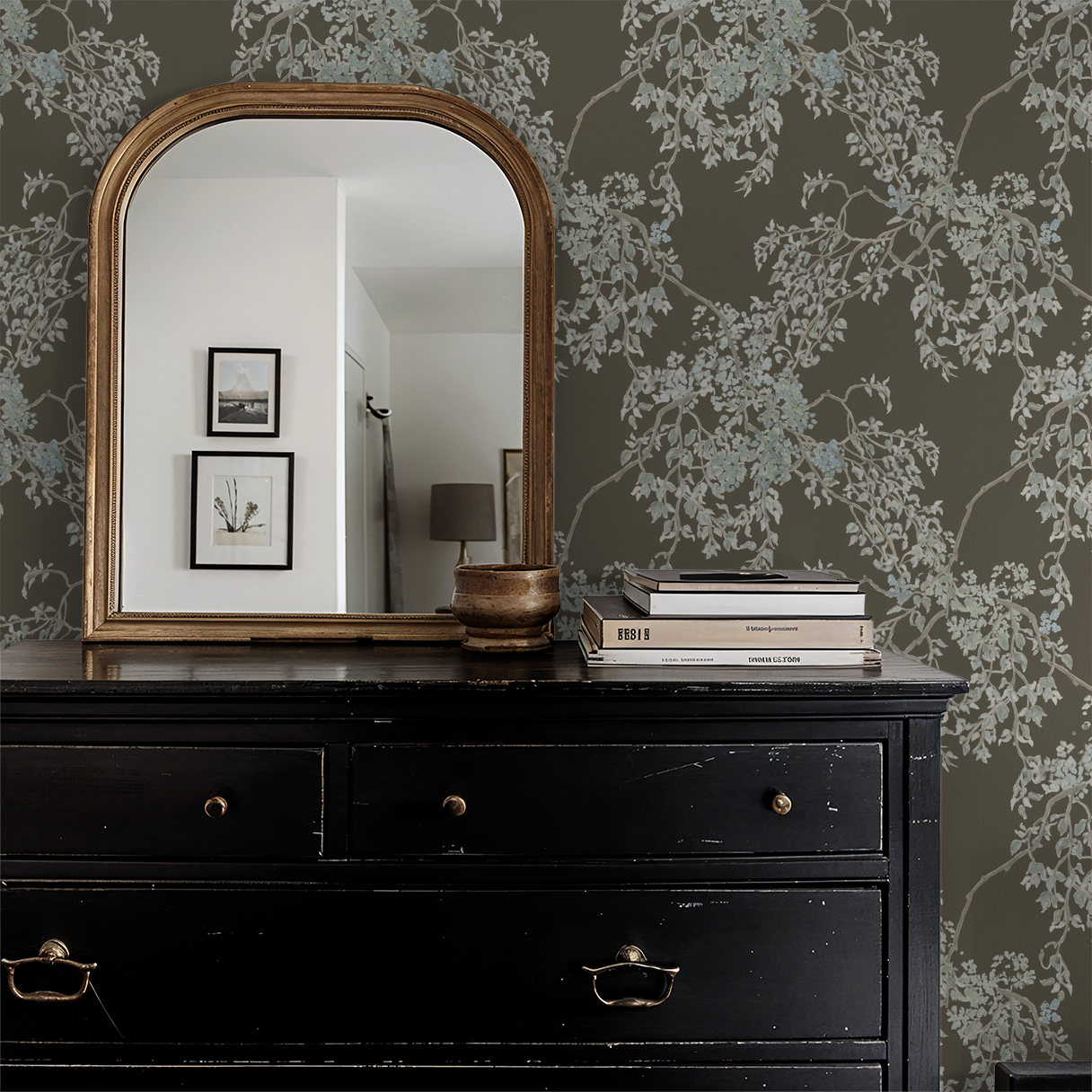 Black dresser with gold accents against a floral wallpapered wall