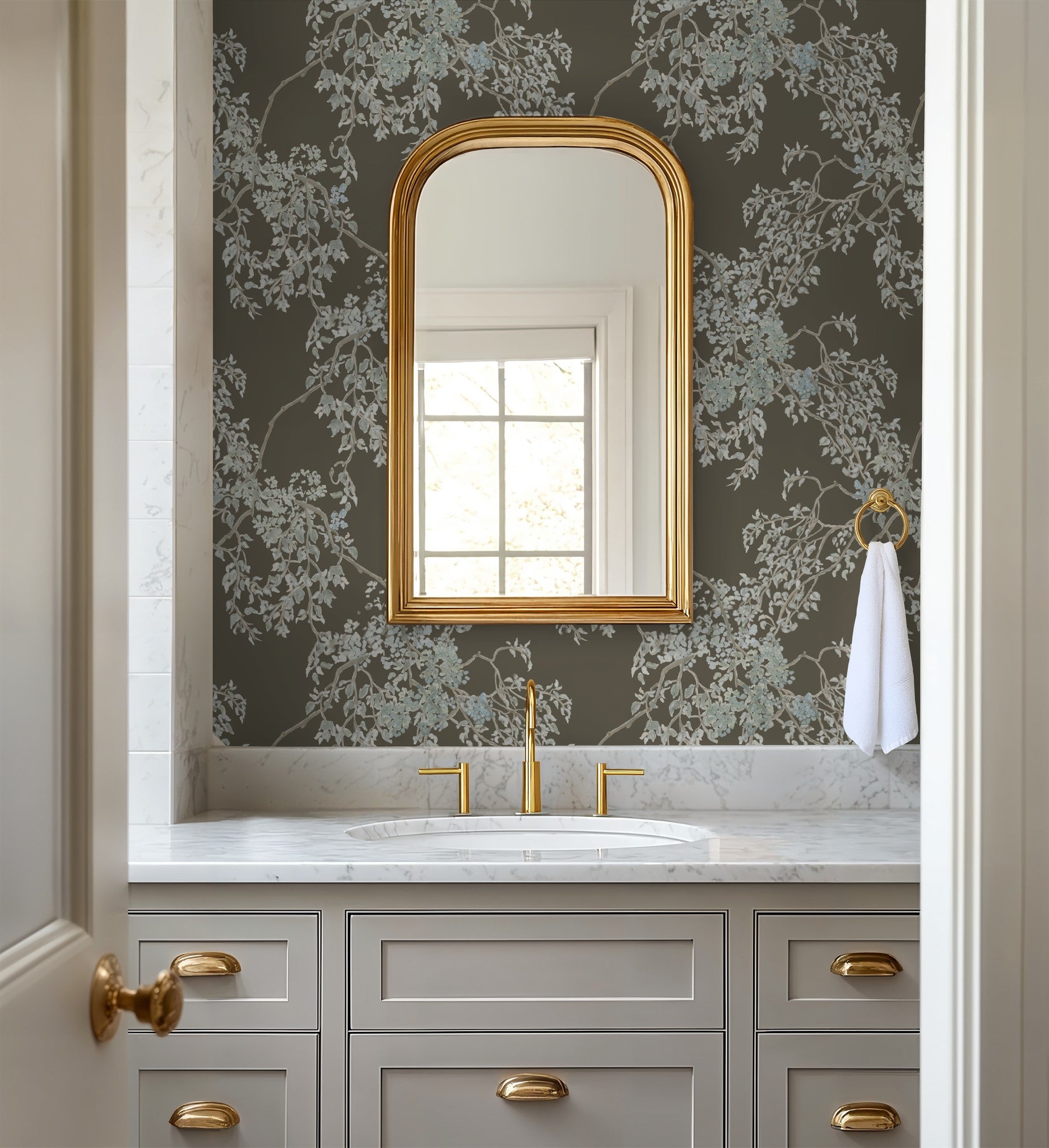 Bathroom with gray vanity, gold fixtures, and floral wallpaper