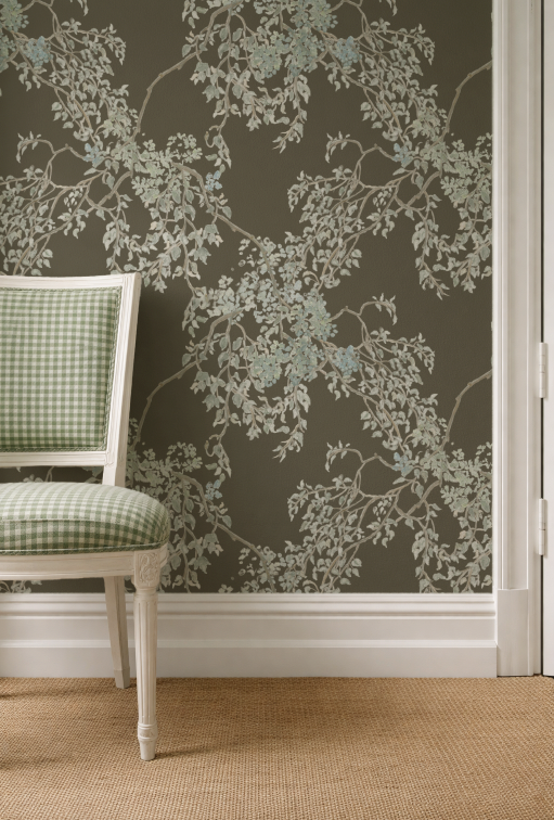 Wallpaper with floral pattern on a wall next to a checkered chair.