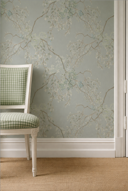 Chair with green checkered pattern against a wall with floral wallpaper