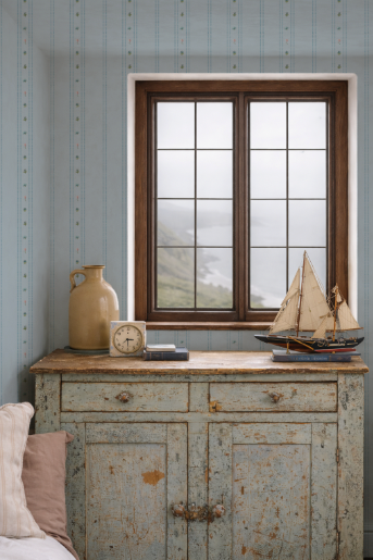 Vintage-style cabinet with a window, decorative items, and a view of a mountainous landscape.