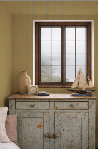 Vintage-style cabinet with a window, decorative items, and a model ship against a yellow wall.